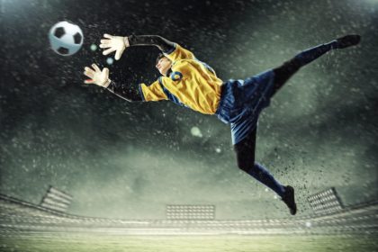 Goalie reaching for soccer ball